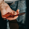 Image of Hand holding a comb with 'Brooklyn Grooming' branding against a blurred background