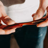 Image of Hand holding a Brooklyn Grooming comb against a neutral background