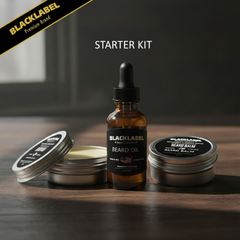 Beard grooming starter kit by Black Label featuring an amber glass dropper bottle of beard oil, an open silver tin of beard balm showing pale balm, and a closed silver tin of beard balm on a dark wooden surface.