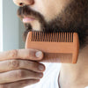 Image of Man holding a wooden comb near his beard