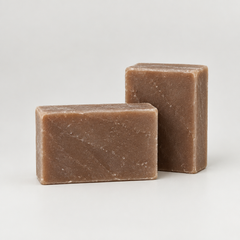 Two rectangular bars of handmade soap in a warm brown color, displayed on a clean white background.